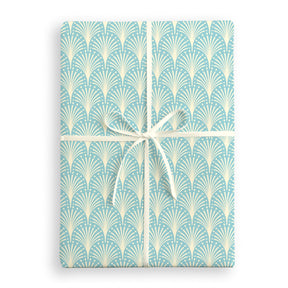 Gift wrap with a blue and white geometric pattern and a white ribbon on a white background