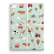 Gift wrapped in farm-themed paper with a white ribbon on a white background