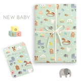 Gift wrap with baby-themed design and matching card on a white background
