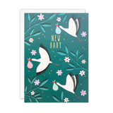 Greeting card with storks carrying baby items on a teal background