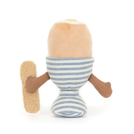 Toy resembling a boiled egg, striped body, and brown arms holding a toast soilder on a white background
