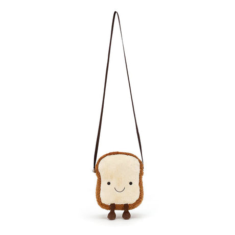 A plush toy resembling a slice of toast with a smiling face, complete with a cross-body strap.
