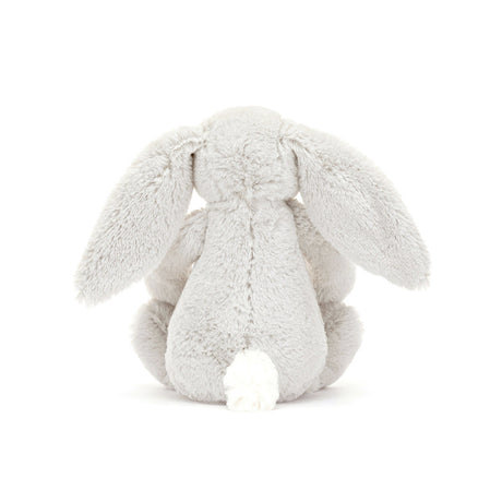 A small plush toy resembling a gray bunny with floral patterns on its ears and feet, and a white backdrop.