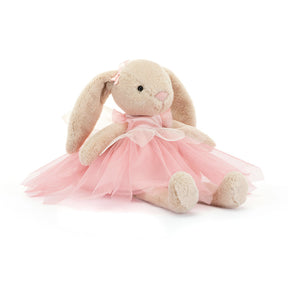 A plush toy resembling a beige bunny with pink ballet attire, including a tutu and bow, sitting against a white background.
