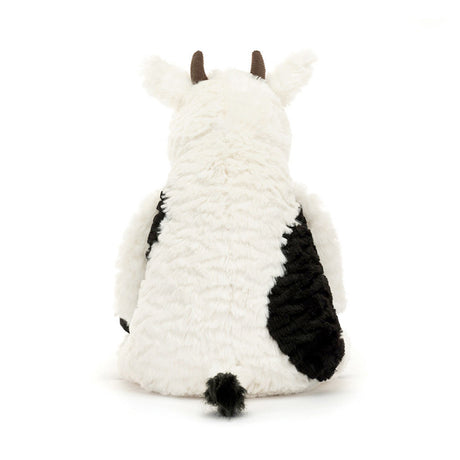 Plush cow toy with black spots on a white background