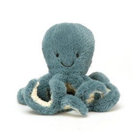 A soft toy resembling an octopus with a smiling face, in teal color with white and darker teal tentacles, and a scruffled cream fur texture.