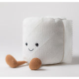 White plush toilet roll with a smiling face and brown feet on a light grey background