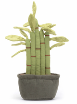 A plush toy resembling a potted bamboo plant with green leaves, red-brown stitch details, and a gray pot. The toy has fluffy soil at the bottom.
