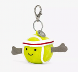 A plush toy in the shape of a yellow tennis ball with red and white details, wearing a white and red headband, attached to a silver clip and chain.