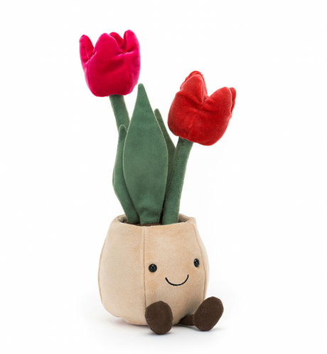 A plush toy depicting a beige pot with two pink tulips and green leaves, designed to look like a cheerful face with brown boots.