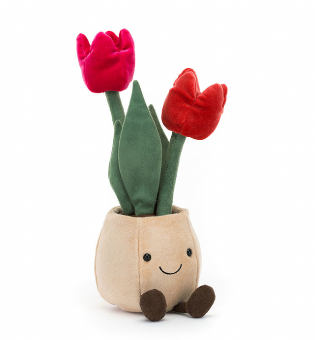 A plush toy depicting a beige pot with two pink tulips and green leaves, designed to look like a cheerful face with brown boots.