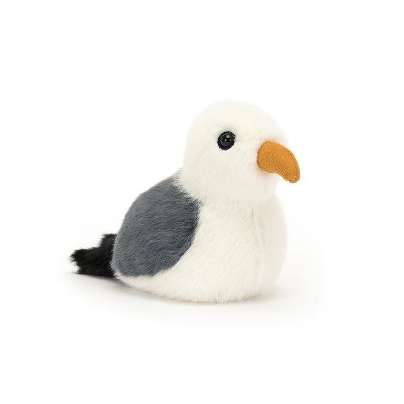 A plush toy resembling a seagull with soft fur in cream, grey, and black, and a suedette mustard beak.