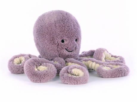 A plush toy resembling an octopus with a smiling face, made of soft purple fabric, with visible white embroidery and stuffed with polyester fibers.
