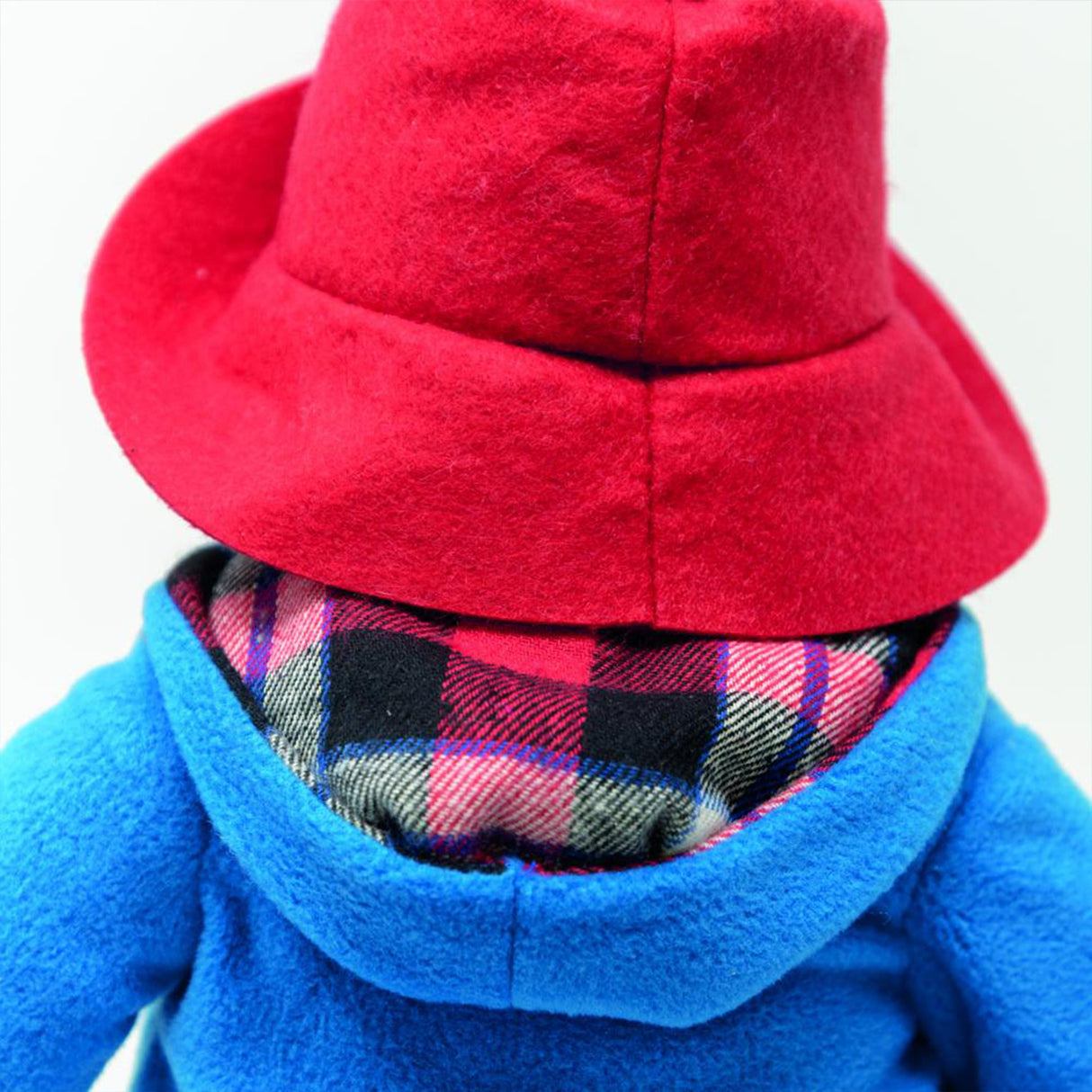 Close-up of a red hat and blue coat with plaid lining on a white background