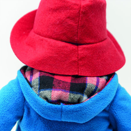 Close-up of a red hat and blue coat with plaid lining on a white background