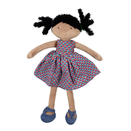 Soft rag doll with dark skin, black hair and a patterned dress on a white background