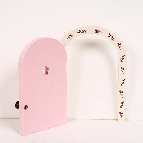 Pink and cream arch-shaped fairy door opened on a light background