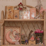 Decorative shelf with small figurines, books, and a vase on a wooden shelf.