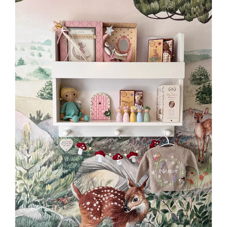 Shelf with decorative items against a nature-themed wallpaper