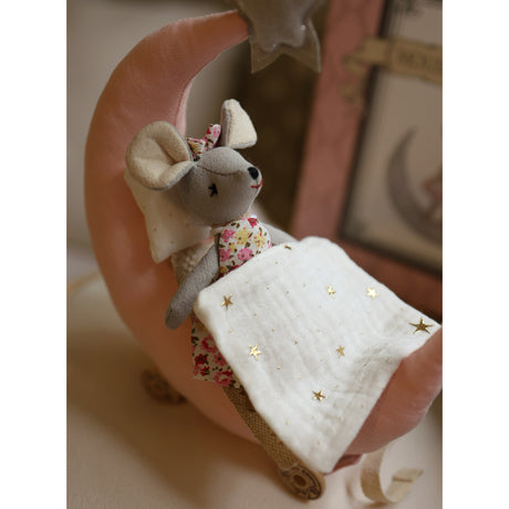 Small plush mouse toy with a floral dress on a pink cushion