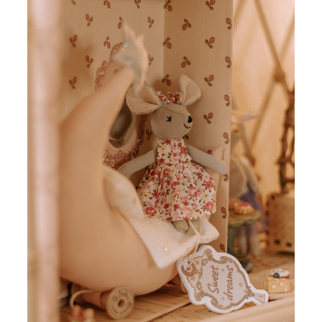 Stuffed mouse with floral dress and 'Sweet dreams' tag, in a cozy room setting.