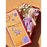 Soft cat toy in a decorative box with flowers on a wooden surface