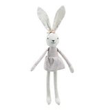 A white linen bunny doll with long ears, a striped dress, and a small bow on its head, photographed against a plain white background.