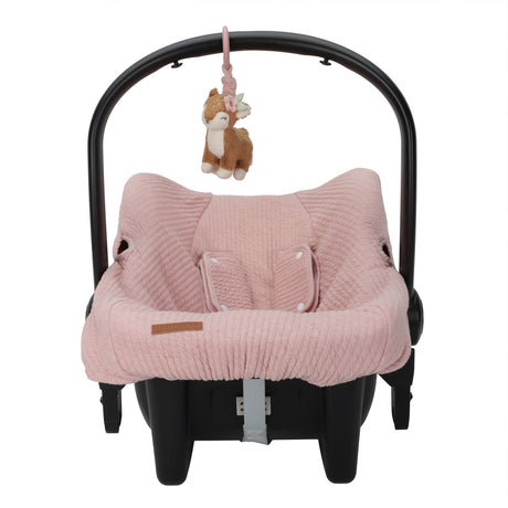 Pink baby car seat with a deer plush toy on a white background