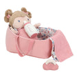 Pink baby crib with a soft doll, bottle, and blanket on a white background