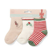 Three pairs of baby socks with festive Christmas designs on a white background