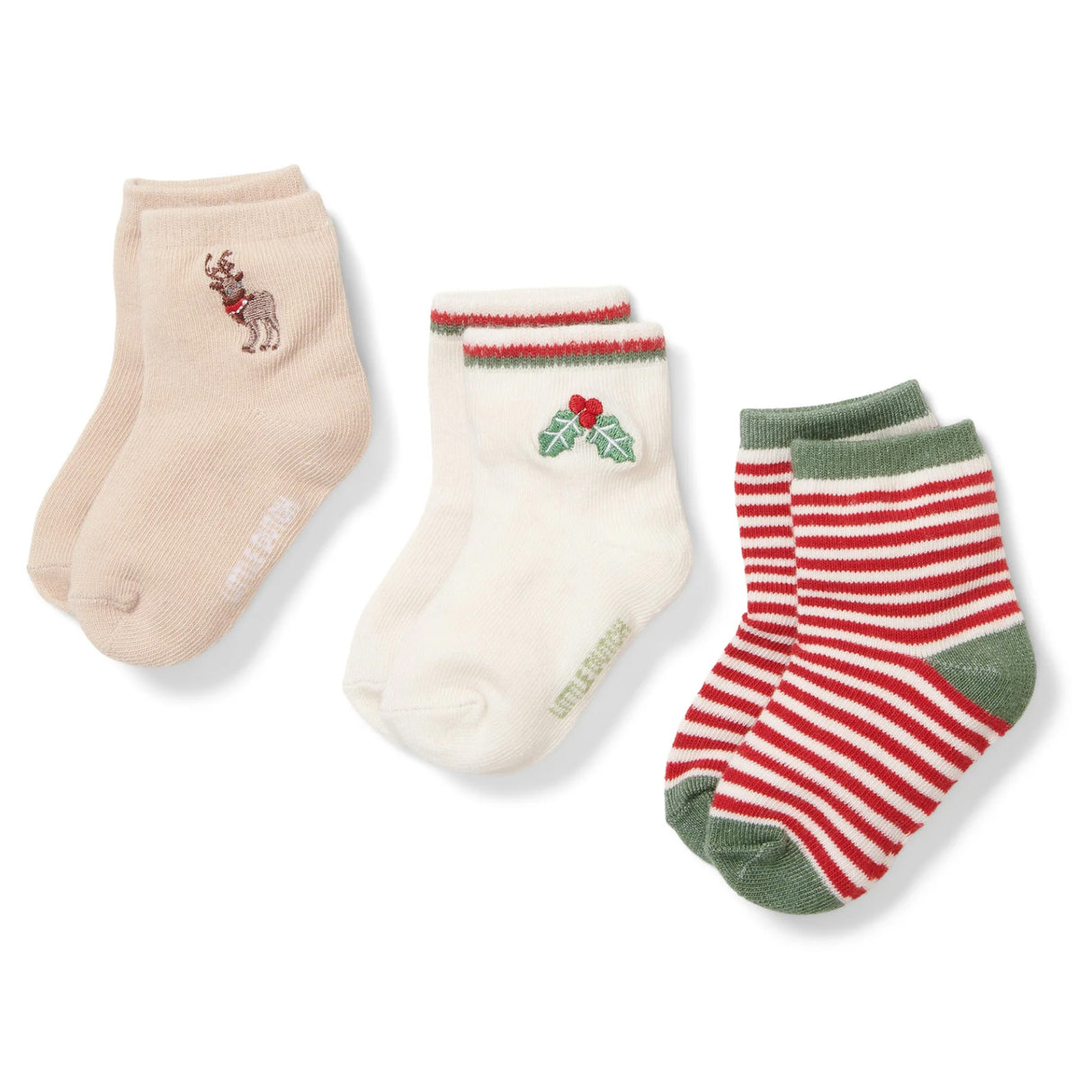 Three pairs of socks with different christmas designs, reindeer, holly and red and white stripes on a white background