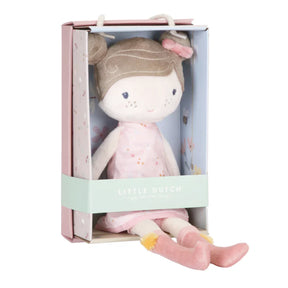 A plush doll named Rosa, with a sweet dress, sitting inside a pink and white striped cardboard box.