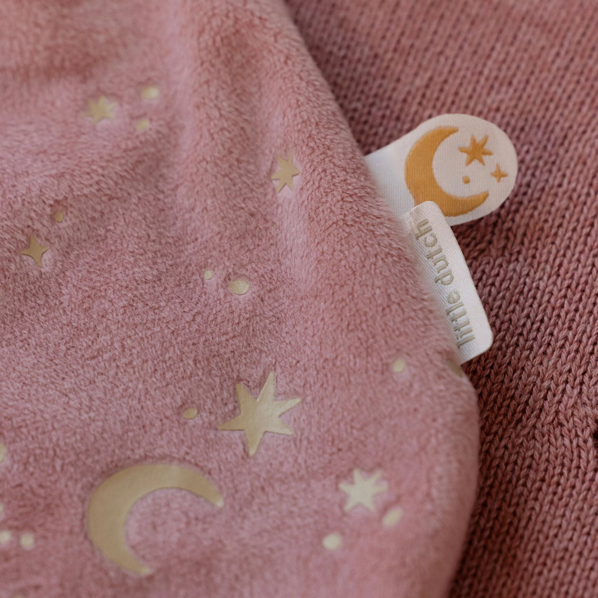 Pink fabric with star and moon patterns and a 'Little Dutch' tag.