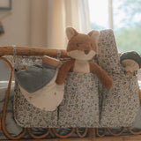 Floral-patterned baby changing bag with a plush fox toy on a wooden crib