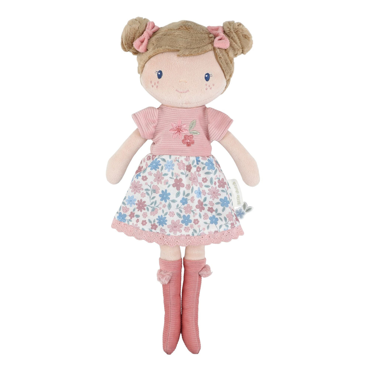 Little Dutch Hug Doll Rosa standing upright, with brown bun hairstyle, pink bows, embroidered floral T-shirt, floral skirt and pink pompom boots, on a white background