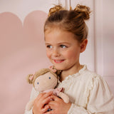 Little Dutch Hug Doll Rosa sitting on a surface, full body view showing floral outfit and pompom boots