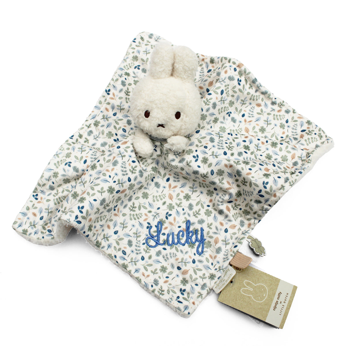 A Miffy-style security blanket with a plush white bunny attached to a cream fabric cover printed with a delicate blue, green, and peach floral pattern. A name is embroidered in blue script on the blanket