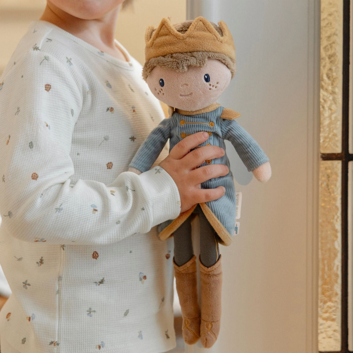 Young child holding Little Dutch Prince Jim Doll 
