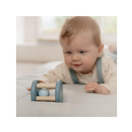 Baby playing with a wooden toy on a light-colored surface