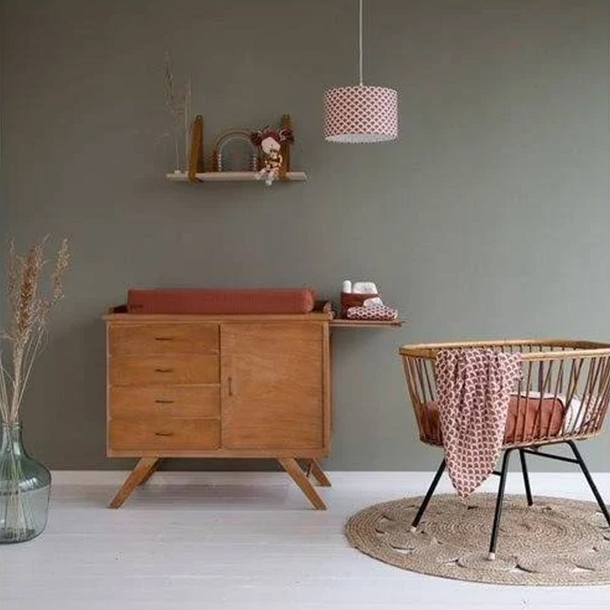 Little Dutch Swaddle Pure Rust styled in a natural wood nursery with rattan cot and changing unit