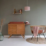 Little Dutch Swaddle Pure Rust styled in a natural wood nursery with rattan cot and changing unit