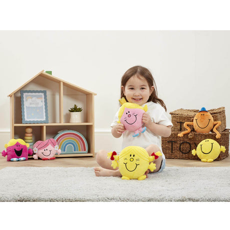 Litlle girl in room with Mr men and Little miss soft toys, holding Little Miss Princess
