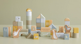 A collection of wooden building blocks in various shapes and sizes, decorated with ducks, birds and a frog. The blocks are in shades of blue, beige, and different colours. 