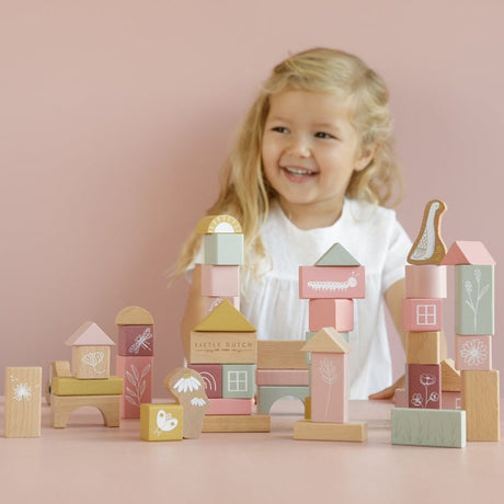 Wooden building blocks with various shapes and sizes, decorated with wild life pictures such as animals and flowers, stacked together