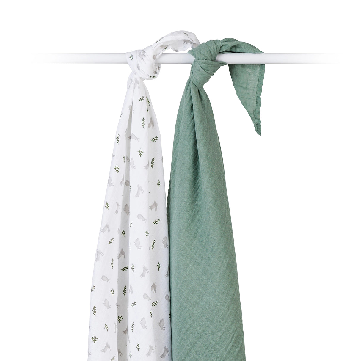 Two baby swaddle blankets one sage green the other with a rabbit and leaf design tied on a white rail on a white background