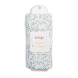 Packaged luLujo swaddle with leaf pattern on a white background