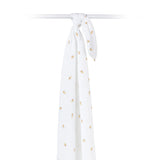Hanging white muslin swaddle with bee patterns on a white background