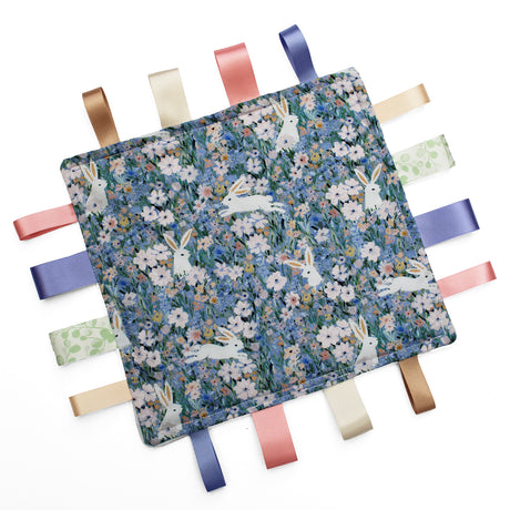 Fabric taggy blanket with rabbit and floral pattern on a white background