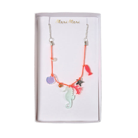 A colorful acrylic necklace with sea creature charms including a starfish, sea horse, and shell, suspended on a neon lace with a silver tone chain and clasps, presented in a clear packaging with 'Meri Meri' branding at the top.