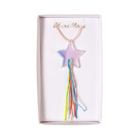 Children's necklace with a shooting star pendant and a rainbow thread tail, displayed in a white box with 'Meri Meri' written on it.